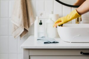 Femme nettoyant la salle de bain avec du vinaigre ménager