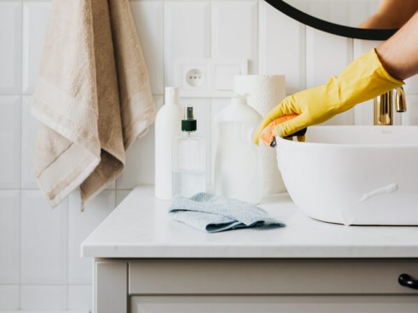 Femme nettoyant la salle de bain avec du vinaigre ménager