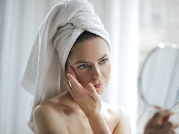 Femme examinant sa peau dans un miroir ©Pexels
