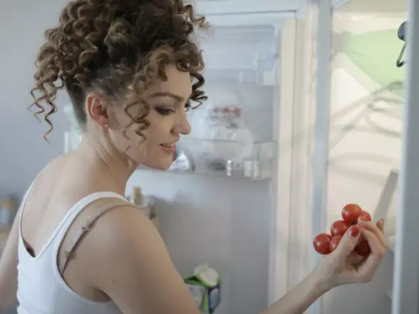 Femme rangeant ses courses dans son réfrigérateur ©Pexels