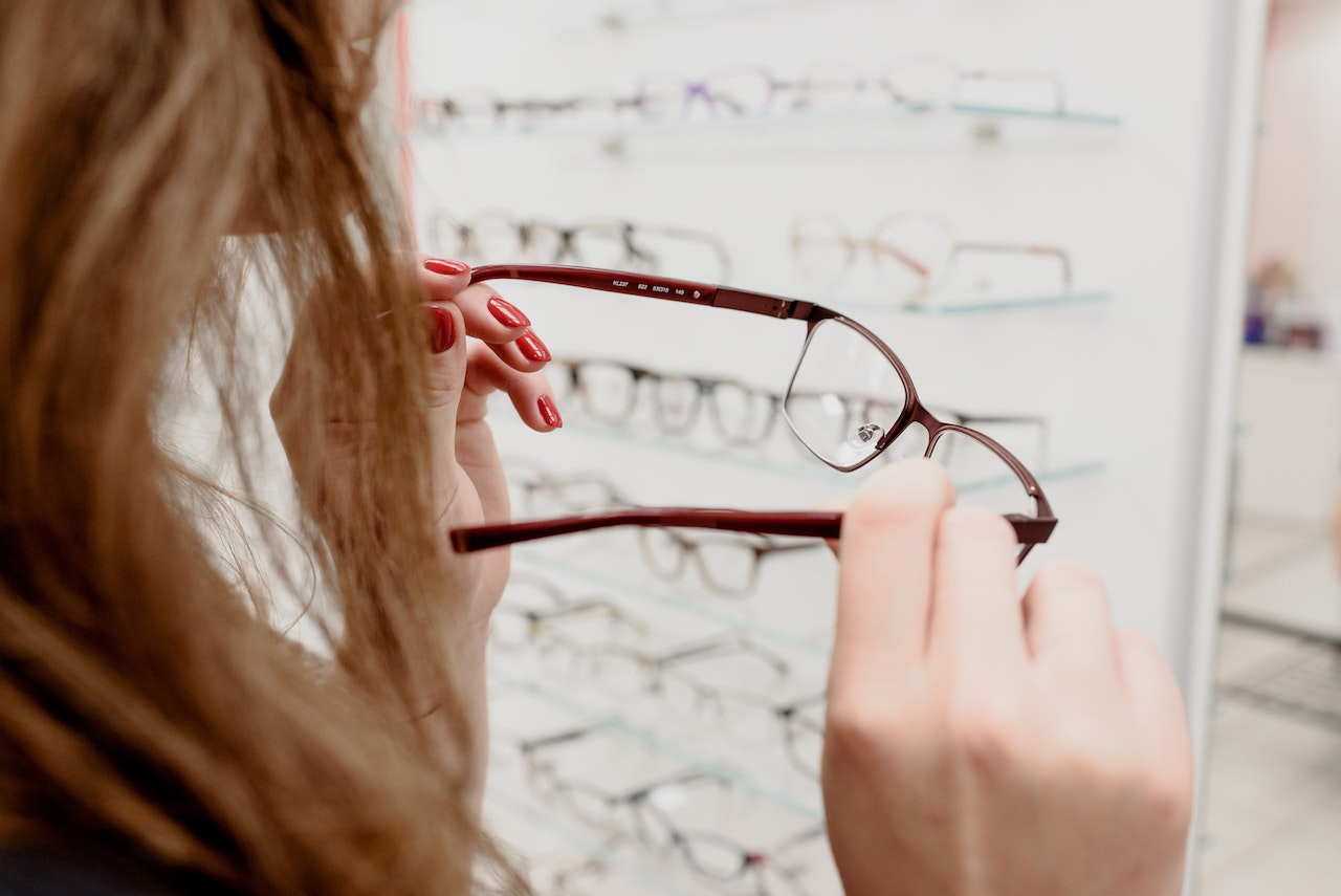 Jeune femme essayant de nouvelles lunettes ©Pexels