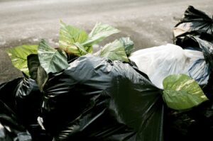 Sacs poubelle entassés dans un jardin ©UnSplash